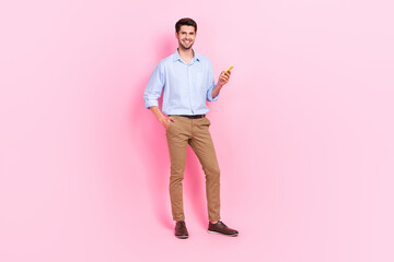 Wall Mural - Full length photo of positive man using new modern device gadget recommend quality telephone isolated on pink color background