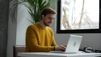 Wall Mural - Young man freelancer entrepreneur using laptop online working from home, surfing web looking at screen enjoying distant job