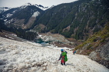 Two Mountaineers Descend Avalanche Chute On Mountainside.