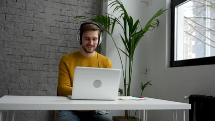 Wall Mural - Young man freelancer entrepreneur using laptop online working from home, surfing web looking at screen enjoying distant job