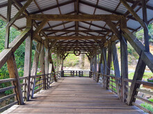 Inside A Covered Wooden Bridge Over A River In A Small Town