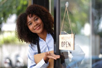 Young African woman small business start-up entrepreneur working in a cafe. Employee working in a coffee shop.