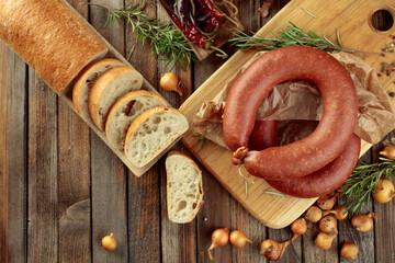 Wall Mural - Smoked sausage with bread and spices on a old wooden table.