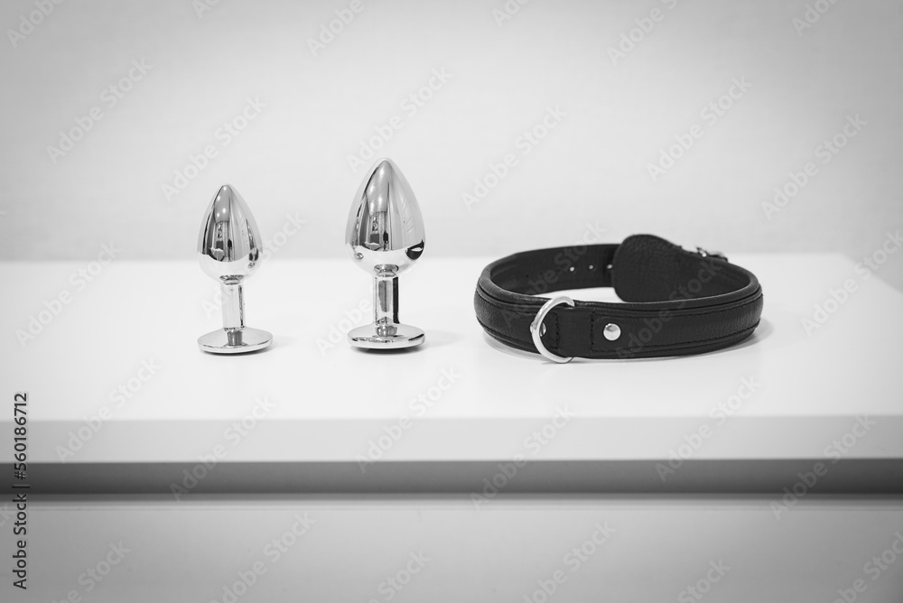 Paddle, collar and anal plug on the table. Domestic discipline. Traditional  corporal punishment implements. BDSM Stock Photo