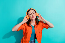 Photo Of Pretty Glad Lady Eyes Closed Wear Stylish Orange Outfit Listening Playlist Favorite Songs Isolated On Cyan Color Background