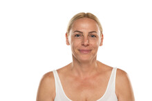 Smiling senior woman without make up Close up face of a mature blonde woman on a white studio background.