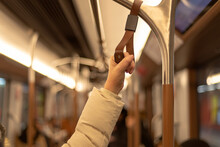 Hand Holding The Handle In Tram, Train, Bus Or Subway. Passenger Standing In Public Transportation