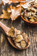 Wall Mural - Sliced dried mushrooms in wooden spoon on wooden table.