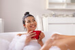 © Wavebreak Media - Image of biracial woman relaxing with cup of tea in bathtub in bubble bath in bathroom