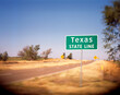 © Cavan Images - A Texas State Line sign on a back road in Oklahoma lets the driver know that they are about to enter the Great State.