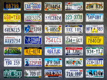 Collection Of Old License Plates Displayed On A Wooden Wall.