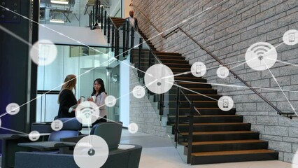 Poster - Animation of network of digital icons over two diverse businesswomen discussing at modern office