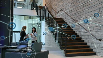 Poster - Animation of network of digital icons over two diverse businesswomen discussing at modern office