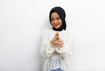 Beautiful smiling Asian woman in a casual shirt looking at camera while aiming with hands isolated on grey background
