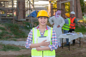 Wall Mural - Diverse team of professionals using tablet computers on construction site. Real estate construction project. with civil engineers, architects, Arabic business investors and explorer with theodolite