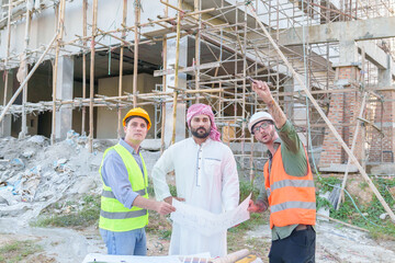 Wall Mural - Diverse team of professionals using tablet computers on construction site. Real estate construction project. with civil engineers, architects, Arabic business investors and explorer with theodolite