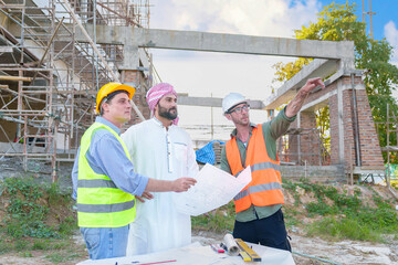 Wall Mural - Diverse team of professionals using tablet computers on construction site. Real estate construction project. with civil engineers, architects, Arabic business investors and explorer with theodolite