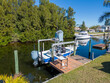 © christian.bitzas - Tower boat with covers on boat lift with deck dock with person on board in Tampa Florida from aerial drone