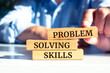 © Uuganbayar - Closeup on businessman holding a wooden block with 'Problem Solving Skills' message, Business concept