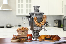 Traditional Russian Samovar And Treats On Wooden Table In Kitchen