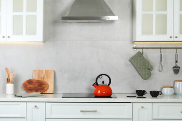 Wall Mural - Red kettle with whistle on cooktop in kitchen