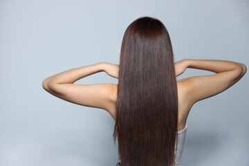 Wall Mural - Young woman with healthy strong hair on light gray background, back view