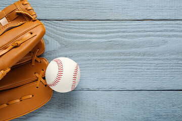 Sticker - Leather baseball glove with ball on grey wooden table, top view. Space for text