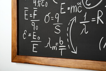 Wall Mural - Blackboard with different physical formulas written with chalk on white wall