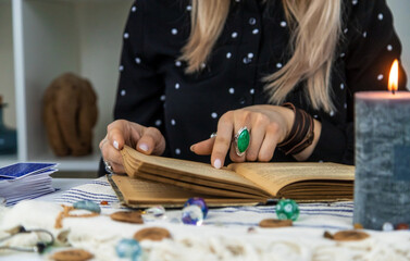 Woman fortune teller reads a book of spells. Selective focus.