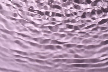 Closeup view of water with rippled surface on violet background