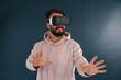 © standret - In VR glasses. Handsome man is in the studio against blue background