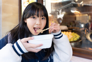 Wall Mural - 鎌倉観光で食べ歩きをする小学生の女の子