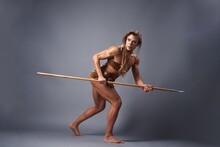 Muscular Female Prehistoric Hunter Crawling With Spear