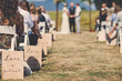 © Cavan Images - People sitting while young couple getting married by priest during sunny day
