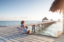 Western Girl On A Wooden Jetty With Straw Hats In Cayo Guillermo Cuba