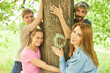 Young people hug a tree while bathing in the forest