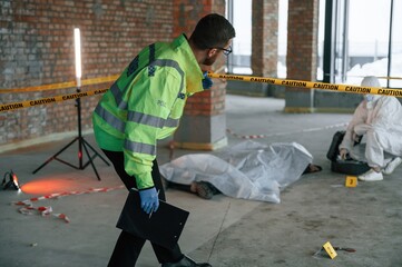 Wall Mural - Detectives are collecting evidence in a crime scene near dead body. Forensic specialists are making expertise