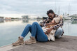© Renata Hamuda - a young couple sitting on the pier, the girl lying in her partner's arms young couple sitting on the pier, the woman lying on her boyfriend's arms outdoors