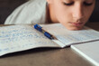 © vejaa - Sad tired boy sitting and looking in to books and notebooks. Education, school, learning difficulties, dyslexia concept
