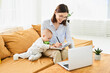 Beautiful happy young mother with newborn baby working in online conference mode.