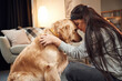 © standret - Close up view, portrait. Woman is with golden retriever dog at home