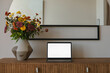 © RooM The Agency - Open laptop with an blank screen and a bouquet of flowers on a wooden sideboard