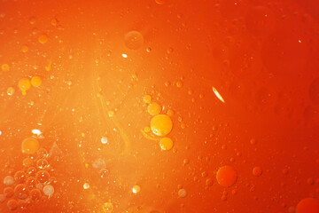 Wall Mural - Gold Oil bubbles close up. circles of orange water macro. abstract shiny yellow background