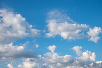 Wall Mural - blue sky background with cumulus clouds, one is in a heart shape. copy space above