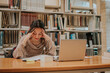 © ADDICTIVE STOCK - Pensive female student reading book in library