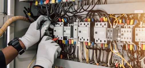 Wall Mural - Electrician engineer tests electrical installations and wires on relay protection system.