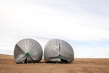 Front View Of Two Steel Grain Bins Toppled Over From A Windstorm In A Rural Autumn Landscape
