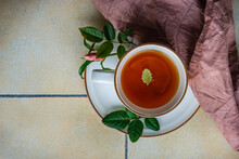 Overhead View Of A Cup Of Tea With A Slice Of Lemon, A Wild Rose Decoration And A Napkin