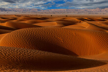 Rippled Sand Dunes In Desert Landscape With Mountain Backdrop, Saudi Arabia