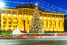 Illuminated Christmas Tree In Front Of Parliament Building On Rustaveli Avenue At Night, Tbilisi, Georgia